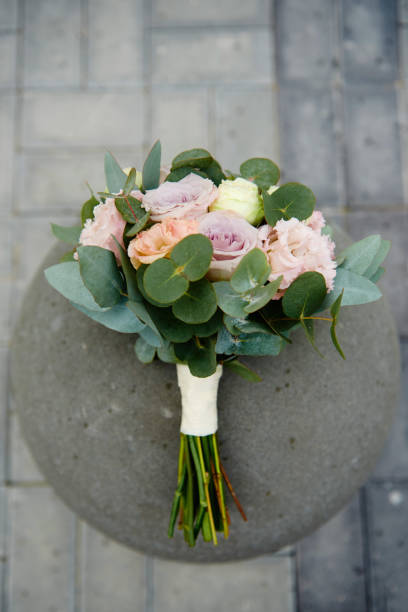 vista dall'alto del bouquet nuziale di rosa, rose viola e vegetazione su sfondo pietra all'aperto, spazio di copia. concetto di matrimonio - small bouquet foto e immagini stock