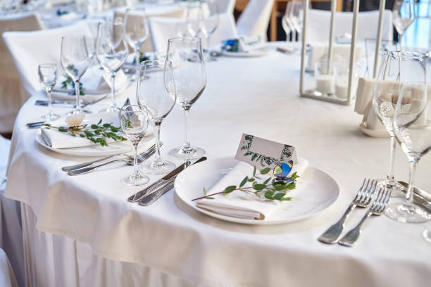 istock Table setting with blank guest card on empty white plate and cutlery on table, copy space. Menu mockup, place setting at wedding reception. Table served for wedding banquet in restauran 1305332648