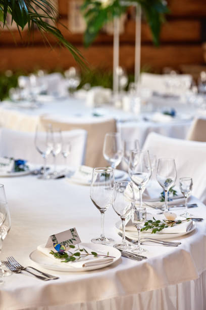 istock Table setting with blank guest card on empty white plate and cutlery on table, copy space. Menu mockup, place setting at wedding reception. Table served for wedding banquet in restauran 1305332663