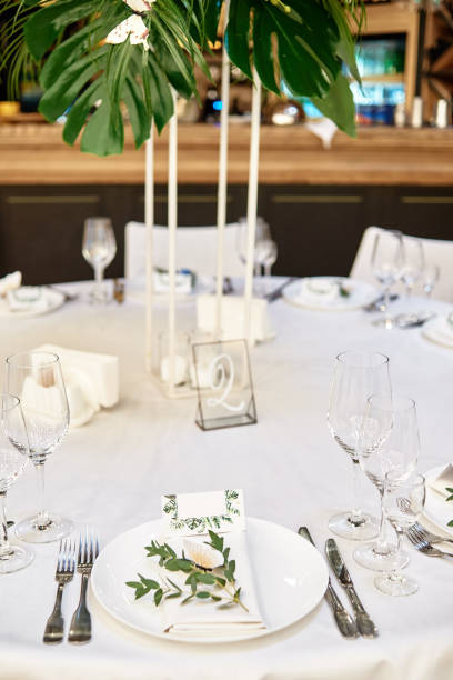 istock Table setting with cutlery, wineglasses and flower decorations on table, copy space. Place setting at wedding reception. Table served for wedding banquet in restauran 1305332680