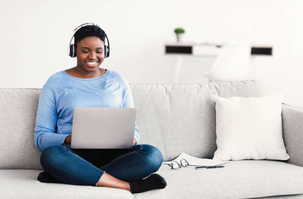 istock Smiling black woman working on computer, wearing headset 1305333870