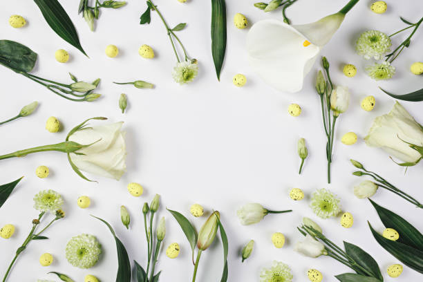 istock Spring floral border frame made with arranged flowers and Easter vibrant eggs against bright white background 1305334701