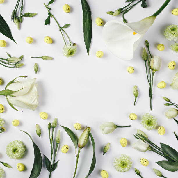 istock Spring floral border frame made with arranged flowers and Easter vibrant eggs against bright white background 1305334817