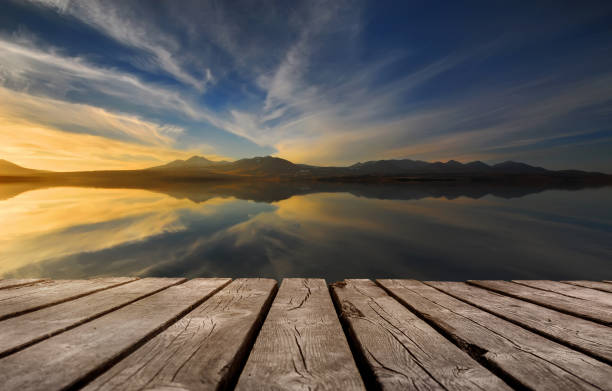 istock beautiful lake with empty wooden table. Natural template landscape 1305335324