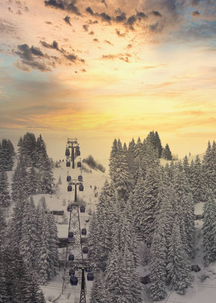 Ski Lift Nasserein Bahn on a snowy day with snowcovered pine trees and mountainrange in the background just before sunset in the skiresort St. Anton, Austria.