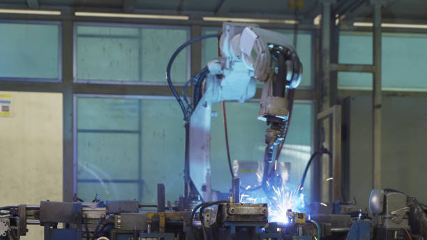 istock Steel smart robot welding hand system automated manufacturing machine engine in factory, industry metal supply chain technology production equipment in operation process warehouse. Welding sparks. 1305338933