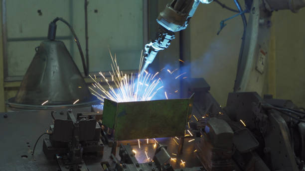 istock Steel smart robot welding hand system automated manufacturing machine engine in factory, industry metal supply chain technology production equipment in operation process warehouse. Welding sparks. 1305338957