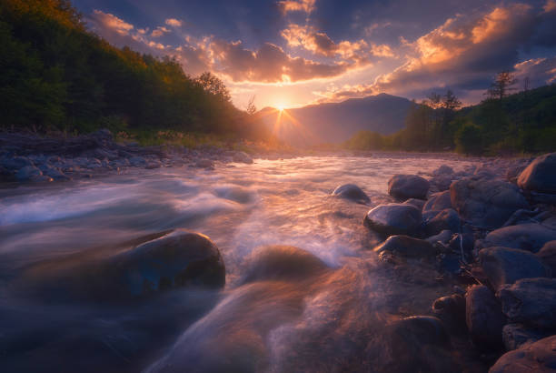 istock Magical sunset over fast flowing mountain river 1305341121
