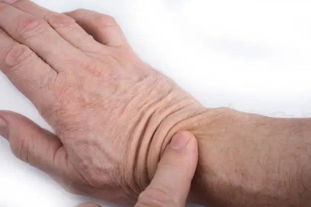 Hand 60 years old man with a wrinkled skin on a white