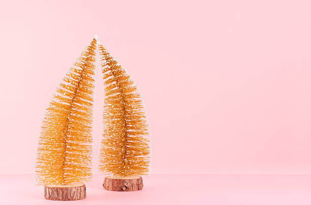 istock Simple gold glitter christmas trees  on stylish pastel pink background. 1305341467