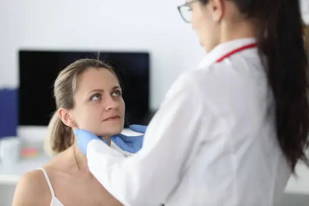 Photo of Doctor examining patients submandibular lymph nodes in clinic