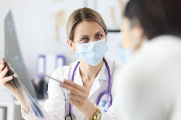 istock Doctor in protective mask showing patient X ray 1305341723