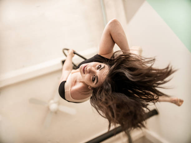Close up of Female aerial dancer on the hoop, practising inside circus studio space.