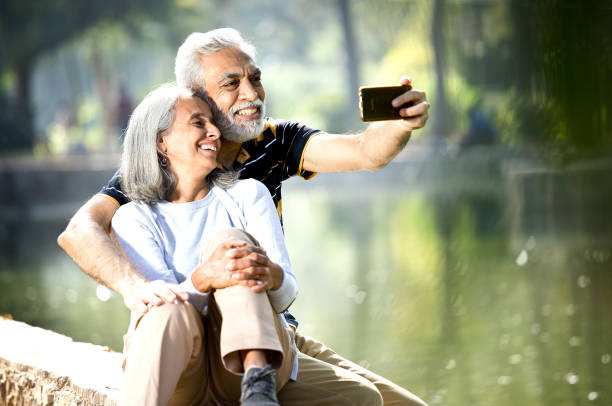 Senior couple taking selfie at lakeshore