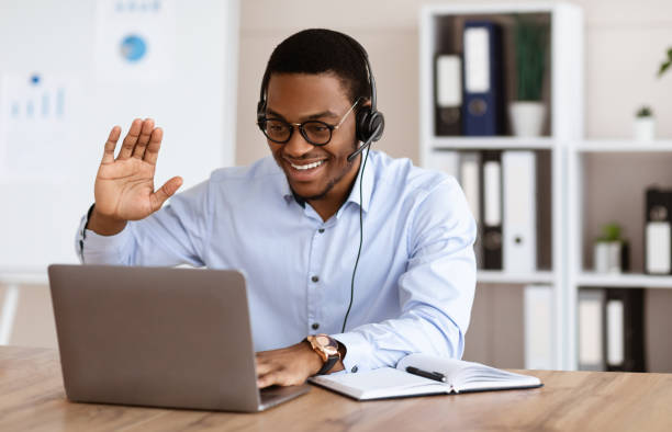 istock Cheerful black guy greeting business partners, having online conference 1305342927