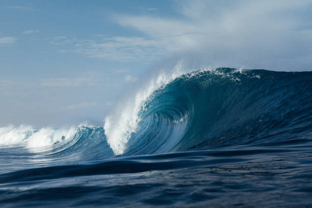 istock Blue wave breaking on a beach in sea 1305342994