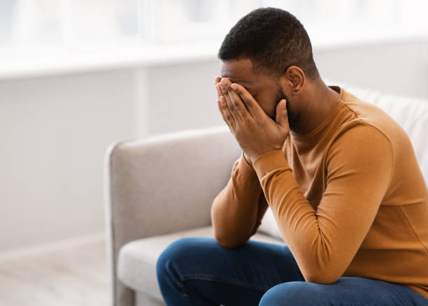 istock Desperate African Man Covering Face Crying Having Depression At Home 1305343064