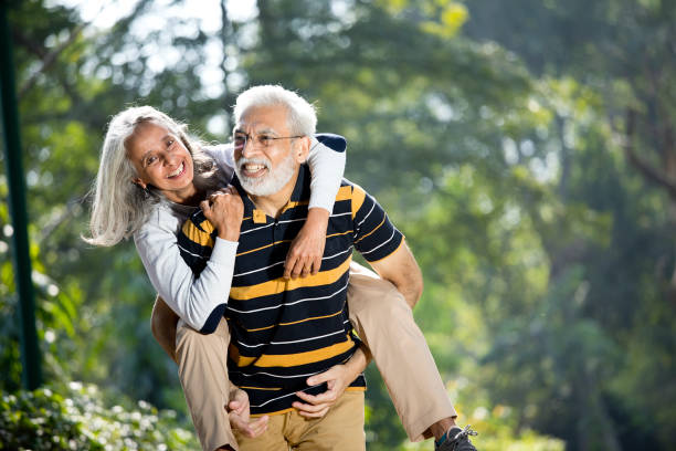 старший человек piggybacking его жена - aging process morning outdoors horizontal стоковые фото и изображения