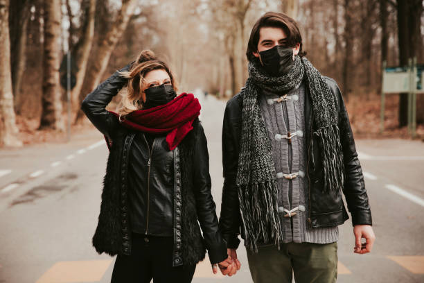 istock couple wearing coronavirus protection mask walking in park 1305345979
