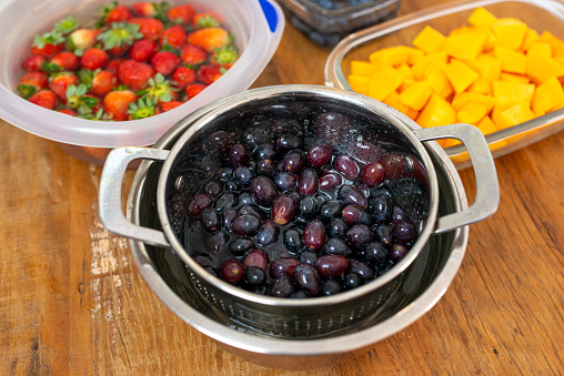 Various fruits being sanitized for the production of homemade jam.