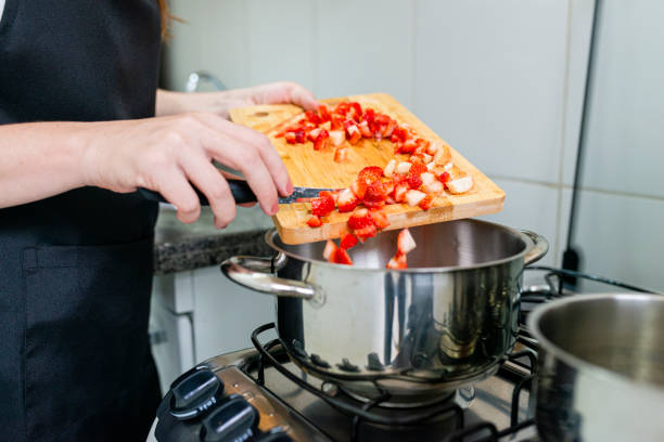 istock Cook pouring strawberry pieces to a boil 1305346872