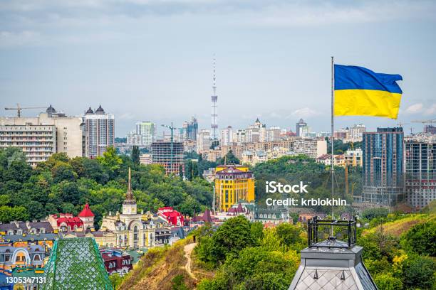 Kyiv Ukraine Cityscape Of Kiev And Ukrainian Flag Waving In The Wind During Summer In Podil District And Colorful New Buildings Stock Photo - Download Image Now
