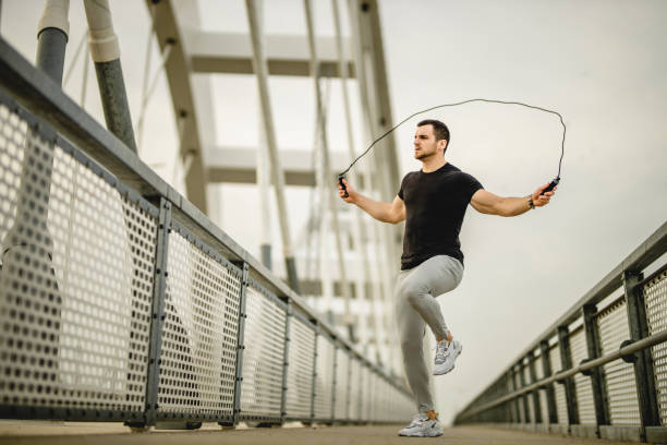 istock Portrait of a handsome young athlete using a skipping rope during an outdoor training session 1305347242