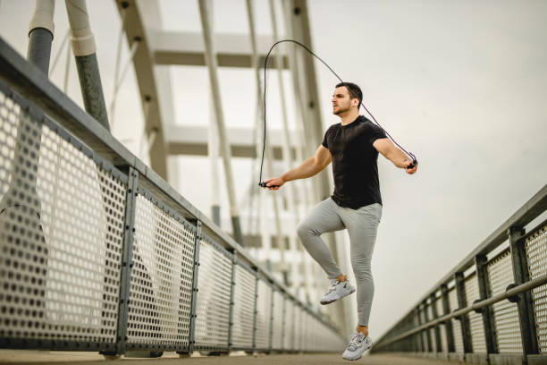 istock Portrait of a handsome young athlete using a skipping rope during an outdoor training session 1305347359