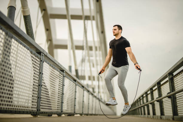 istock Portrait of a handsome young athlete using a skipping rope during an outdoor training session 1305347404