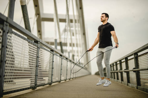 istock Portrait of a handsome young athlete using a skipping rope during an outdoor training session 1305347472