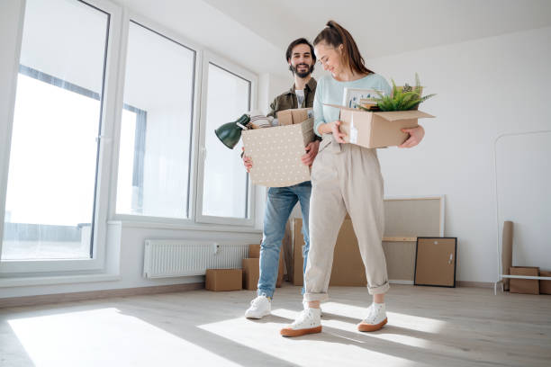 istock Young couple with boxes moving in new flat, new home and relocation concept. 1305348281
