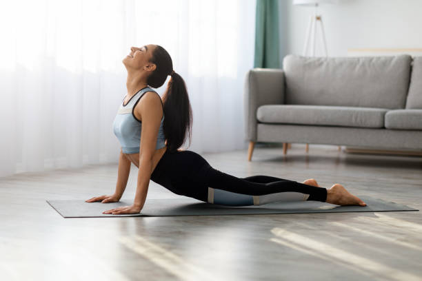 istock Flexible young woman practicing yoga at home 1305349676