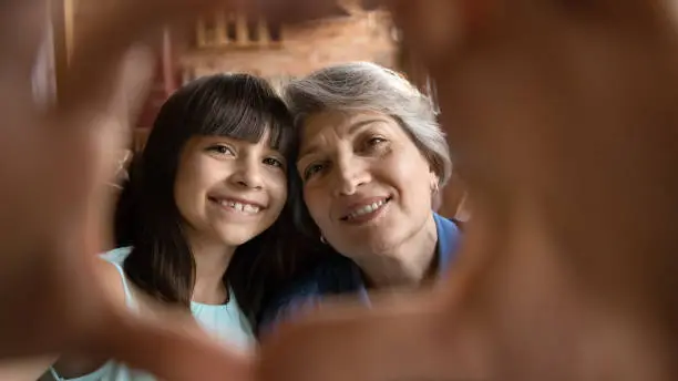 Photo of Portrait of happy Hispanic grandmother and little granddaughter