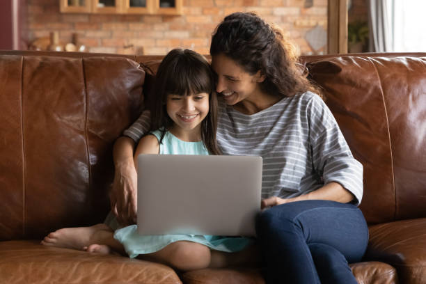 istock Happy Hispanic mom and small daughter use laptop 1305351011