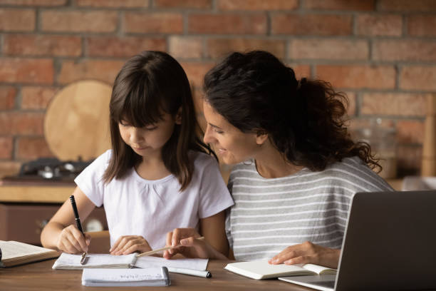 istock Young Latino mom help daughter with school preparation 1305351073