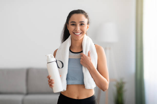 istock Cheerful brunette woman having break after training at home 1305351389