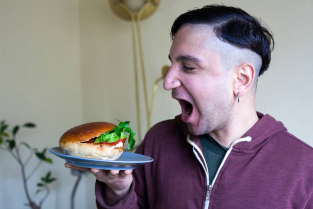 istock Man starting to eat a delicious sandwich 1305351543
