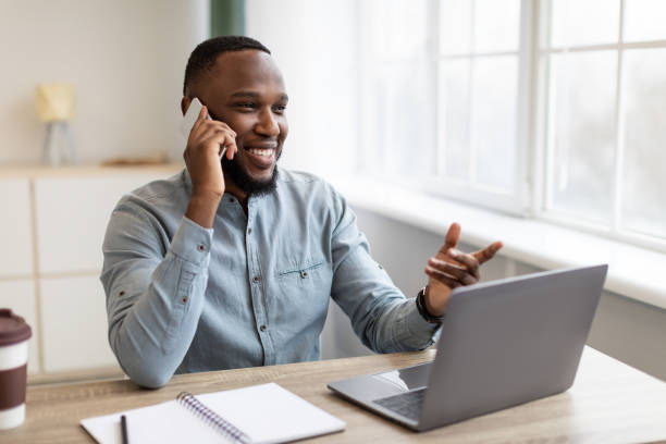 istock African American Businessman Talking On Mobile Phone Sitting At Workplace 1305351673