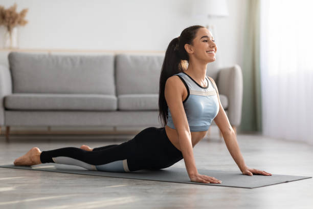 istock Active young woman practicing yoga at home 1305352424