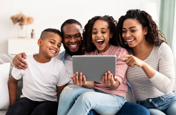 istock Happy african american family holding and using digital tablet computer 1305352476