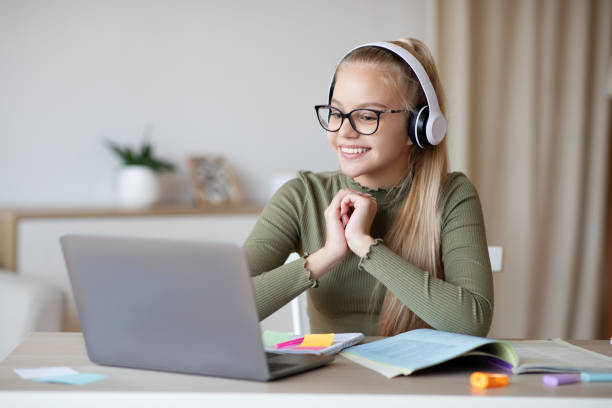istock Girl in headset looking at laptop screen, watching online lesson 1305352764