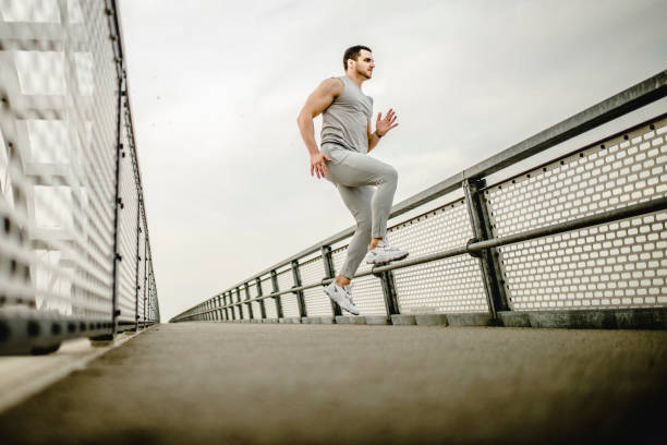 istock Young fit man exercising and running outdoors 1305353633