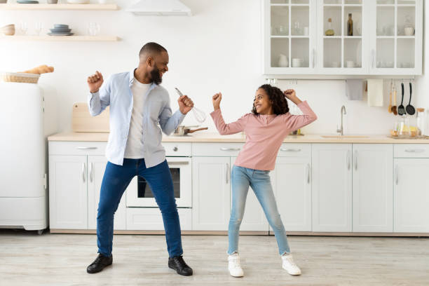 istock Black dad and daughter dancing while cooking together 1305355502