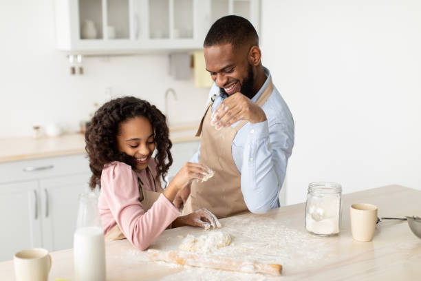 istock Black man and his daughter playing with flour 1305355613