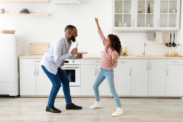 istock Black father and daughter dancing in the kitchen together 1305355700