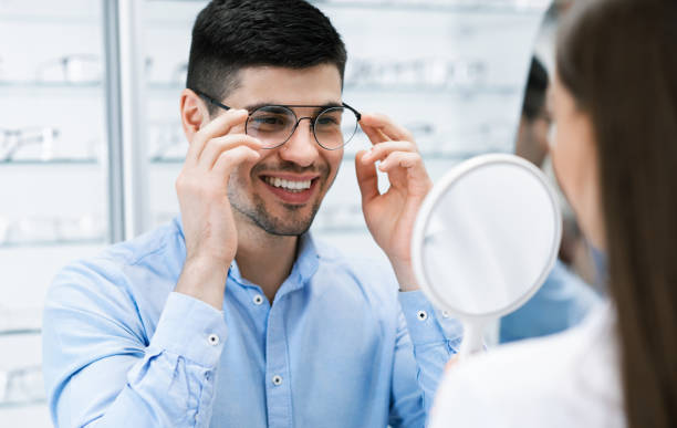 istock Optometrist helping smiling guy to choose correction glasses 1305356494
