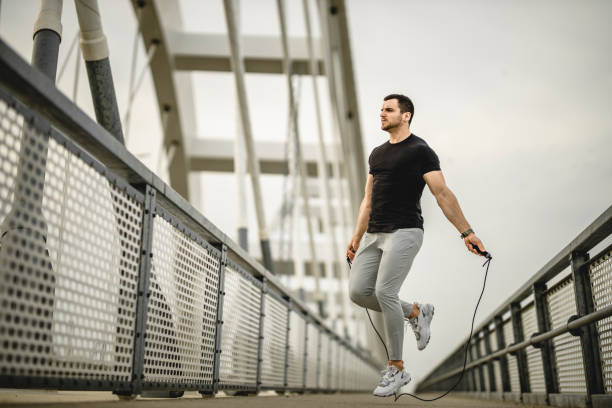 istock Portrait of a handsome young athlete using a skipping rope during an outdoor training session 1305357963