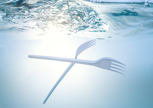 The global ecological problem, environmental pollution, waste in the seas and rivers. Plastic fork under water