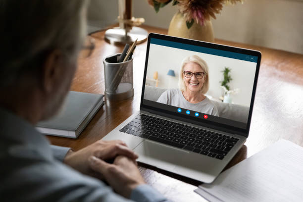 happy mature couple chatting online via video call - aging process middle women men imagens e fotografias de stock