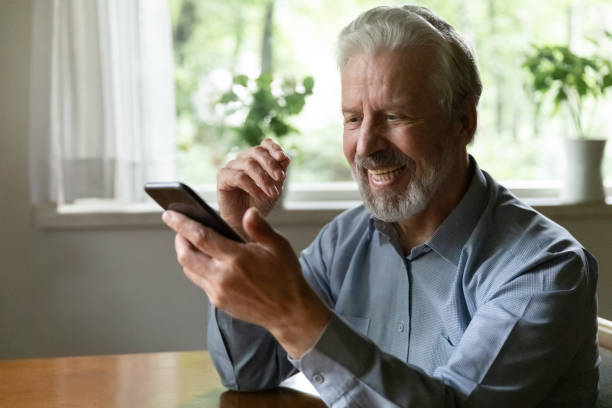 istock Happy senior 70s aged man using smartphone for video call 1305359976